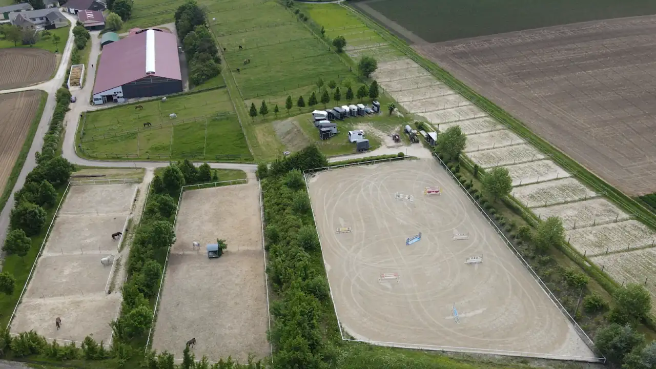 Luftbild der Reitanlage in Maisbirbaum: Reithalle, Springplatz und Koppeln zwischen den Feldern